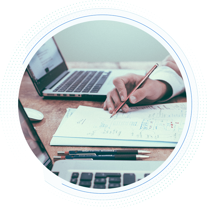 person-holding-pencil-with-paperwork-on-desk